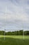 Green grass pitch with tall goal post for Irish National sport hurling and camogie. Popular game with ball and wooden stick. Blue