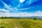 Green grass, rural road and clouds