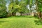 Green grass and a shed in empty fenced back yard