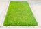 Green grass on square concrete block