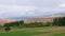 Green grass on summer meadow on highlands landscape and cloudy sky timelapse.