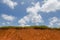 Green grass on top of clay hill and blue sky