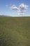 Green grass, white puffy clouds and Topa Topa Mountains as verticle