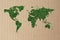 Green grass world map on cardboard background. World Environment Day June 5