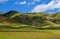 Green grassland, mountains, blue sky and white clouds