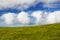 Green grasslands against a dramatic sky