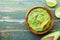 Green guacamole with ingredients avocado, lime and nachos on wooden vintage table top view. Traditional mexican food.