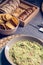 Green guacamole Mexican sauce food on a plate with bread toast slices close up still no a dark dinning table