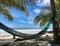 Green hammock on coconut palm in a wild beach