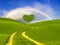 Green heart-shaped tree on a spring meadow-symbol of love and Valentine`s Day