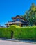 Green hedge with arch over entrance gate in front of residential house.