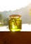 Green herbal honey with pine needles inside. Eco friendly food. Natural concept of healthy lifestyle. Curte jar in summer lights