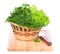Green herbs in a basket on chopping board on white