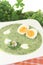 Green herbs soup with eggs and a dollop of cream