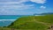 Green Hill at the Seashore in Bali with Emerald Colored Ocean, White Sand and Blue Sky