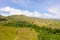 Green hills and blue sky with clouds. Beautiful landscape on the island of Luzon, aerial view.