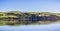 Green hills reflected on the calm waters of Tomales Bay, North San Francisco Bay Area, California