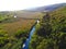 Green hilly country side landscape with trees and plants and river lake