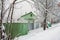 Green house behind greeny fence in the snow