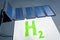 Green hydrogen concept. Solar panel connected to H2 text, symbolizing the generation of hydrogen from solar energy