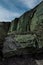 Green ignimbrite rock formations on the beach in southern iceland. Volcanic conglomerate with boulders and cobbles around