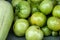 Green immature tomatoes lying on a bench