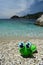 Green inflatable frog on a deserted pebble beach