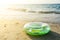 Green inflatable round tube on the sand beach with sunlight in the evening