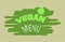 green inscription vegan menu with one leaf on a green background from large stripes