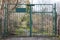 Green iron fence with a gate at the forest or field entrance is forbidden, secret, personal or military territory. protection of