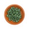 Green iron supplement tablets in a small bowl