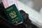 Green Islamic Republic of Pakistan passport with airline tickets on touristic backpack