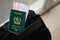 Green Islamic Republic of Pakistan passport with airline tickets on touristic backpack