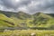 Green island on Lough Callee and waterfalls on mountainside of Carrauntoohil mountain