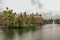 Green isle on the Hofvijver lake with the Binnenhof Gothic government buildings and cloudy sky in The Hague.