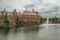 Green isle on the Hofvijver lake with the Binnenhof Gothic government buildings and cloudy sky in The Hague.