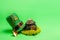 On green isolated background St. Patricks hat, leprechaun kettle with gold coins, shovel, horseshoe
