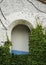 Green ivy on an old building with arch opening