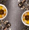 Green Jasmine tea with fresh flowers and tea cups on black stone background, frame, top view