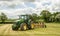 Green john deere 7820 tractor pulling a plough