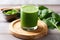 green juice in a stem glass on a wooden chopping board