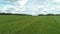 Green juicy fields with haystacks. Shot. Beautiful twisted haystacks on cleared green field on background cloudy sky