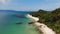 Green jungle and stony beach near sea. Tropical rainforest and rocks near calm blue sea on white sandy shore of Koh Samui paradise