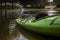 Green kayak on the river bank