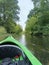 Green kayak, surrounded by the lush beauty of trees