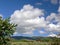 Green landscape with small village and huge cloud above