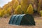 Green large basecamp tent on colorful mountains background