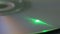 Green laser beam reading or writing data on rotating cd or dvd disc, macro