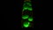 Green lava lamp on black background. Concept. Beautiful neon-lit lava lamp in total darkness. Retro neon night light