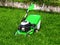 Green lawnmower trimmer in thick dense grass closeup